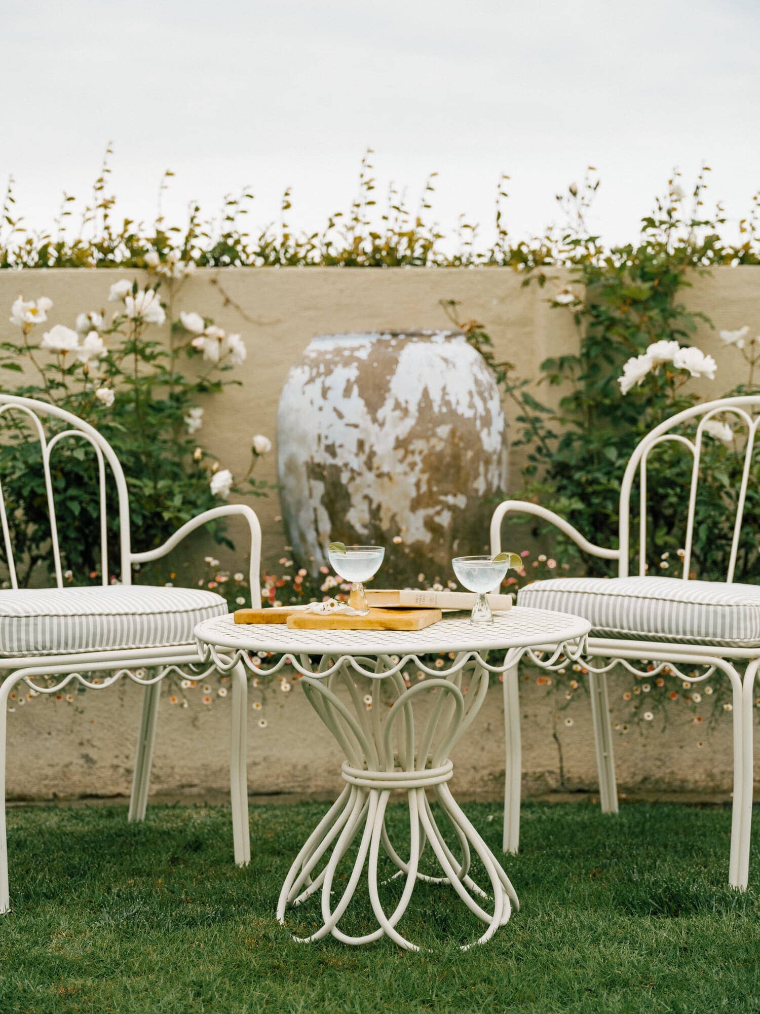 White al fresco chairs and side table in a garden
