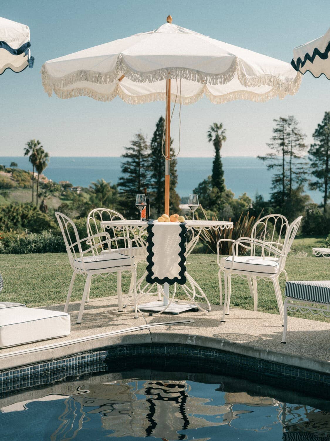 Al fresco dining table with chairs on a poolside patio
