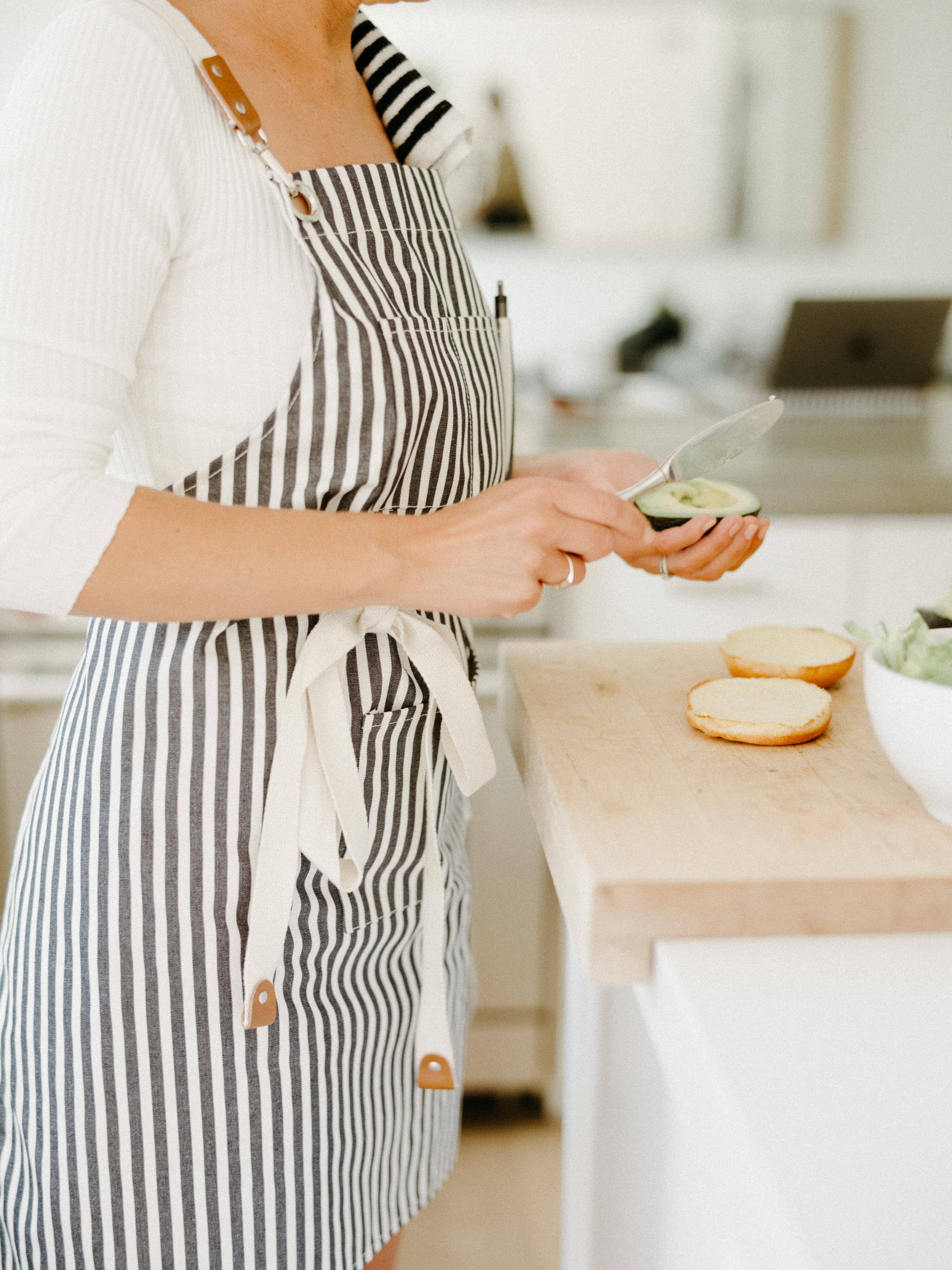 Chef cooking in kitchen wearing navy apron