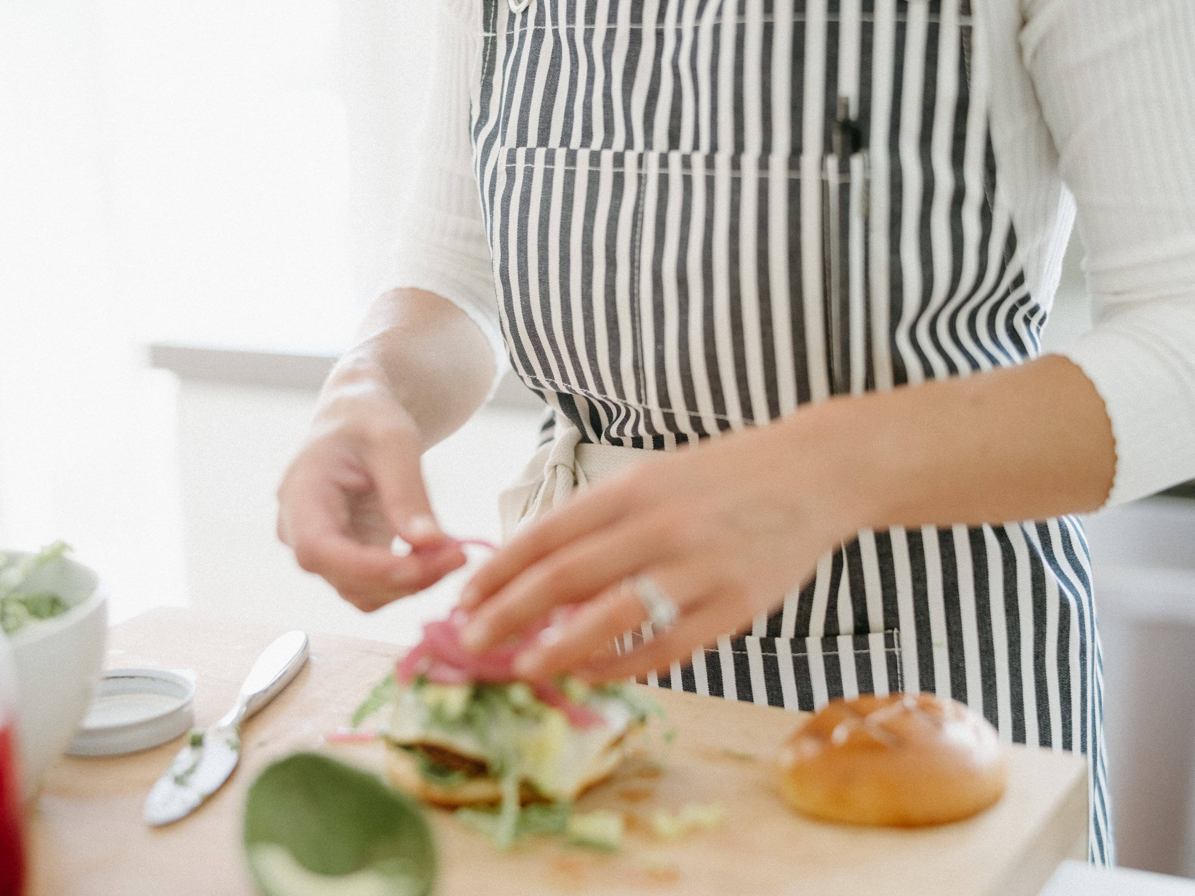 Chef cooking in kitchen wearing navy apron
