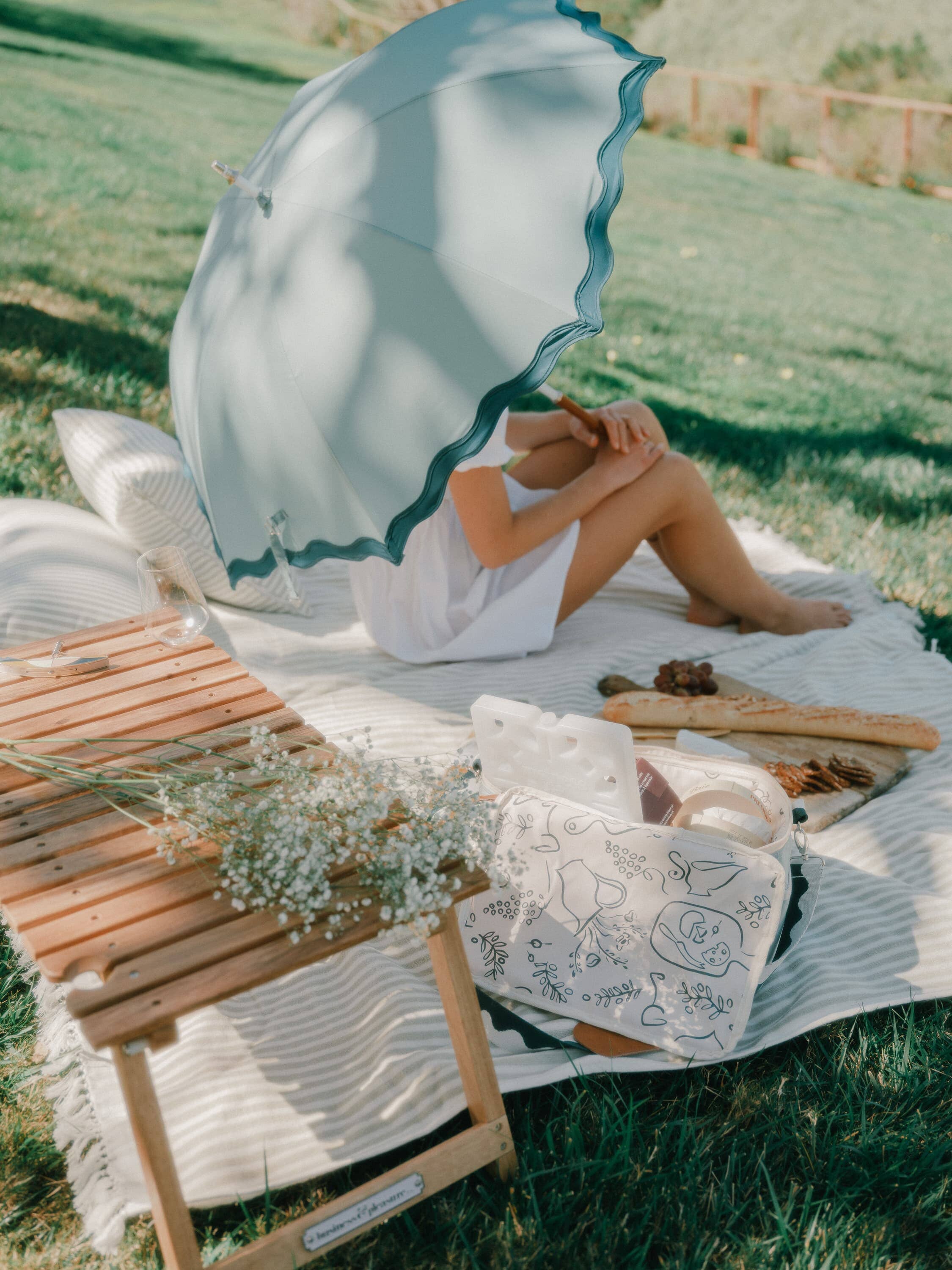 Picnic setting with riviera green rain umbrella, table and cooler