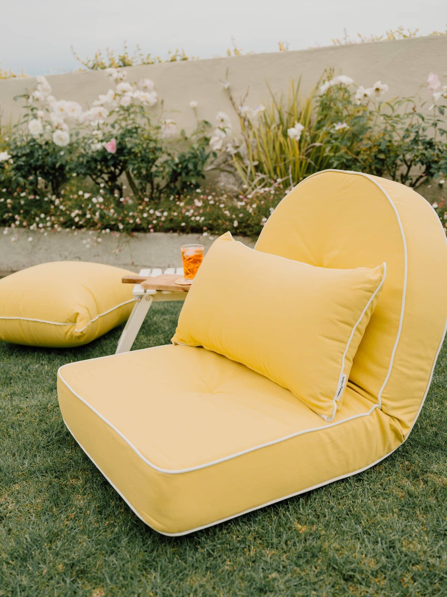 Riviera mimosa outdoor pillows in a garden setting