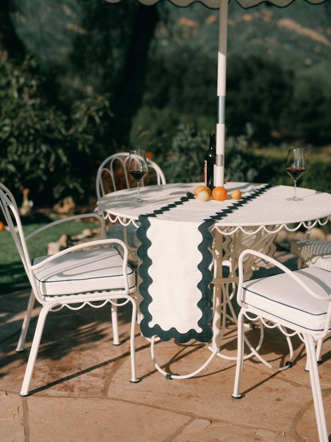 Al fresco dining table with chairs on a poolside patio