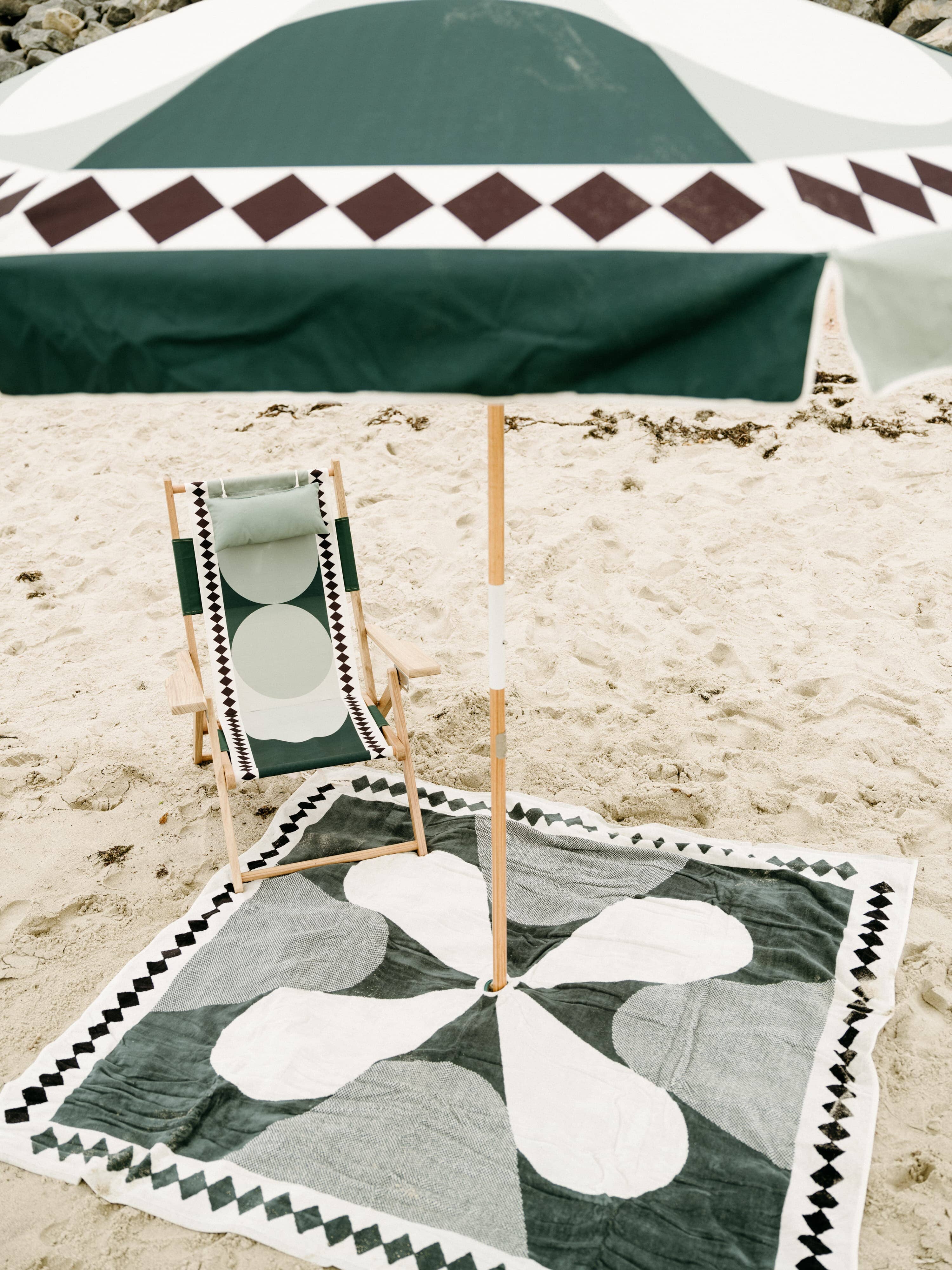 Beach set up with blanket, chair and umbrella