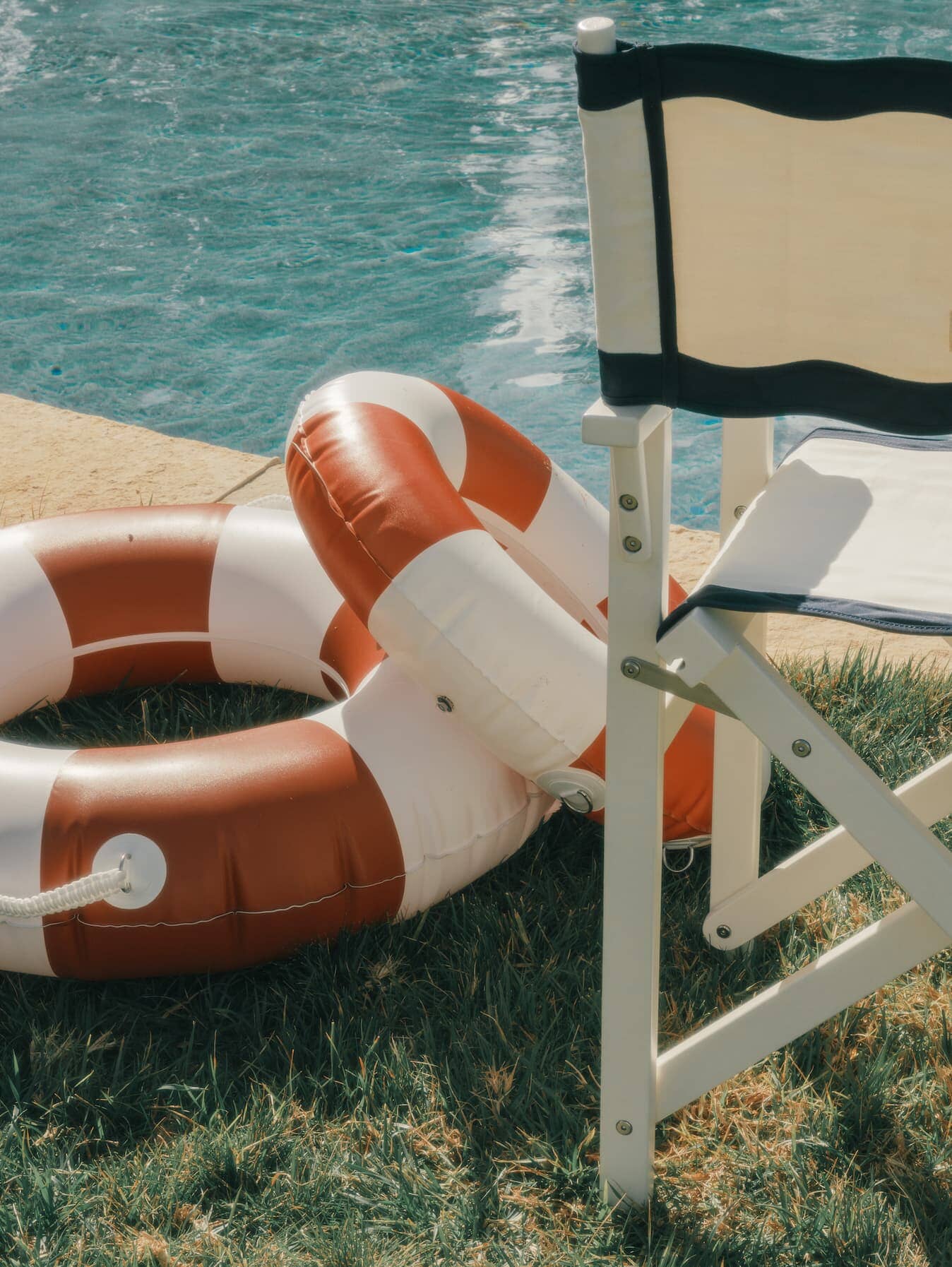 Riviera white directors chair next to a pool