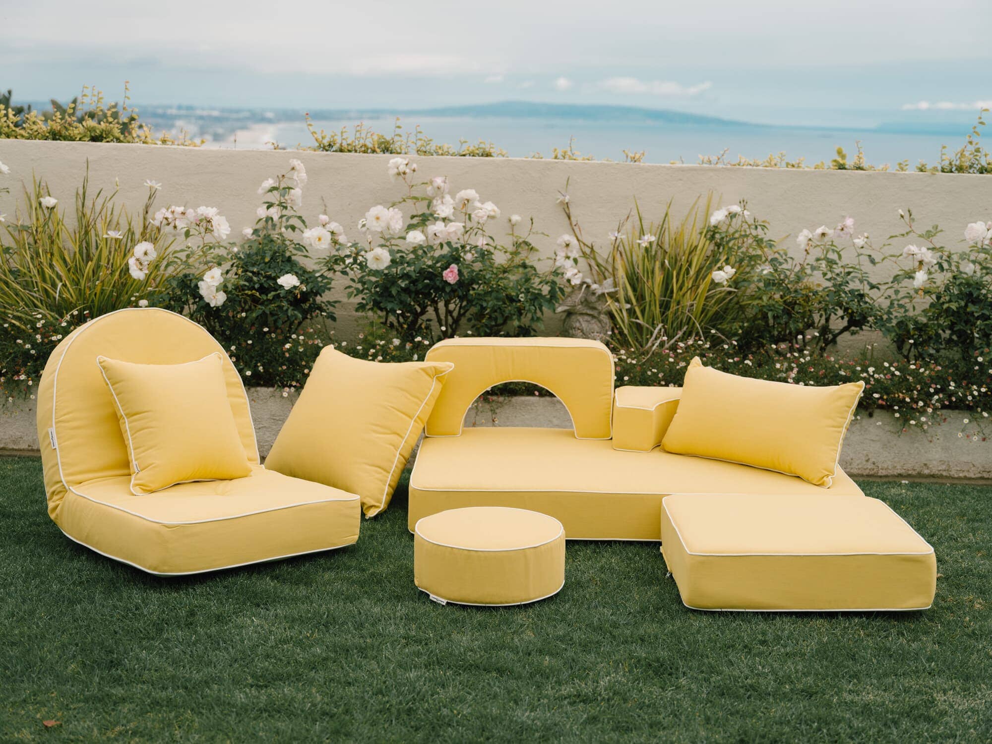 Riviera mimosa outdoor pillows in a garden setting