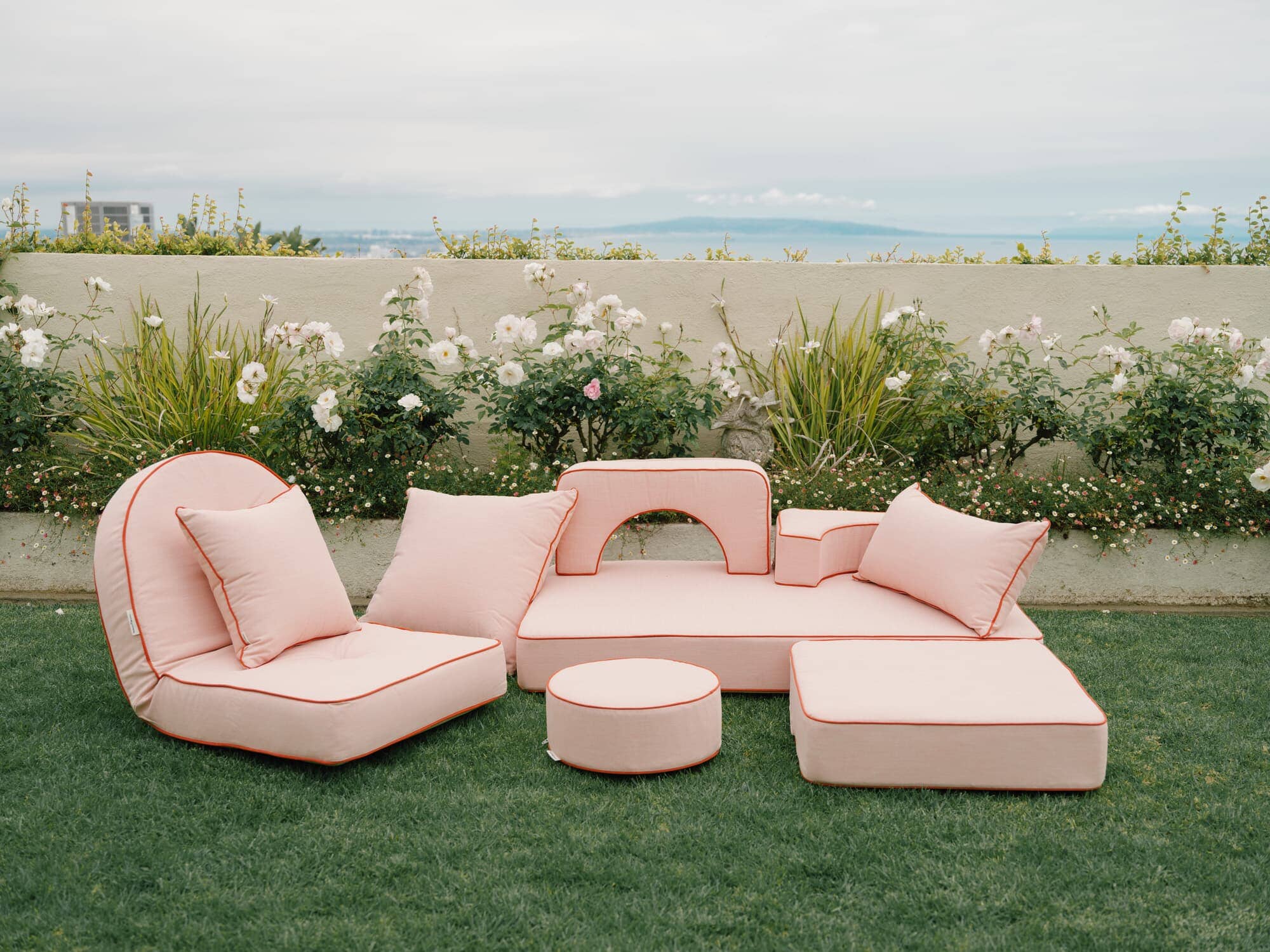 Riviera pink outdoor pillows in a garden setting
