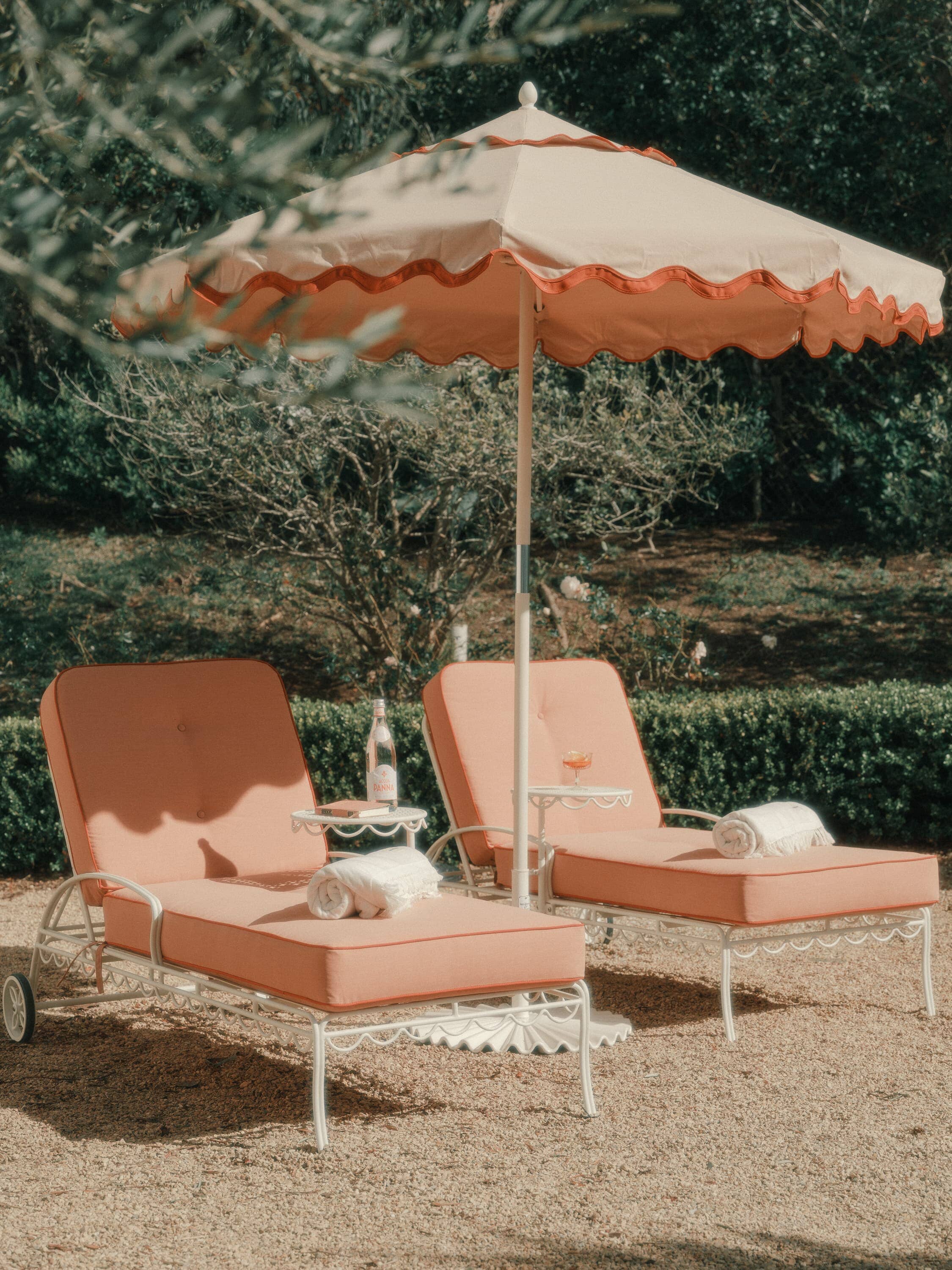 Riviera pink market umbrellas and sun loungers in a garden