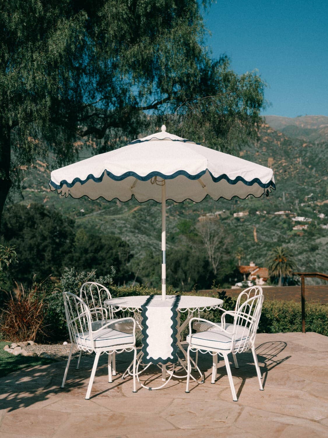 Outdoor patio with riviera white market umbrella, table and chairs. 