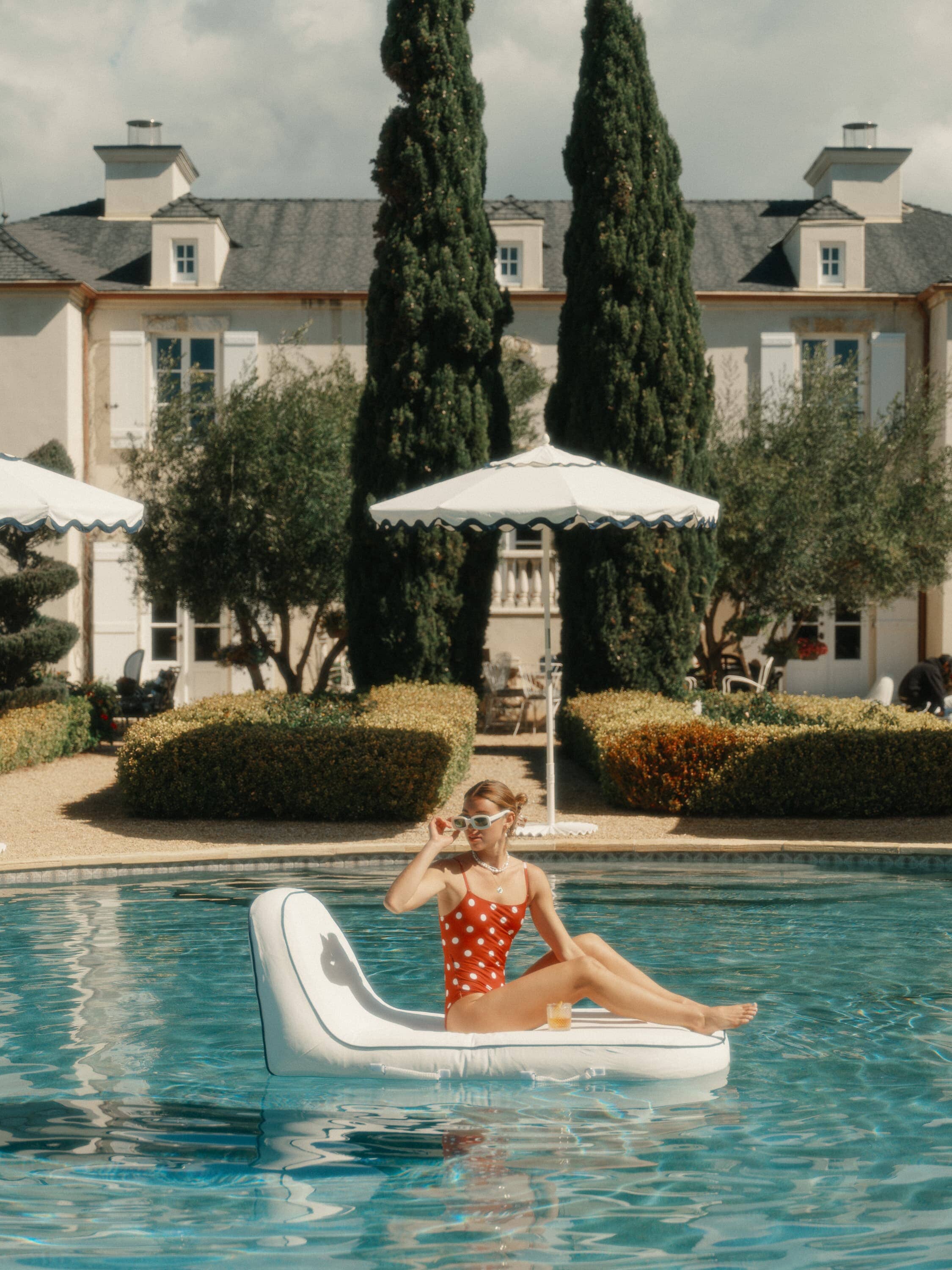 Woman on pool lounger in a pool