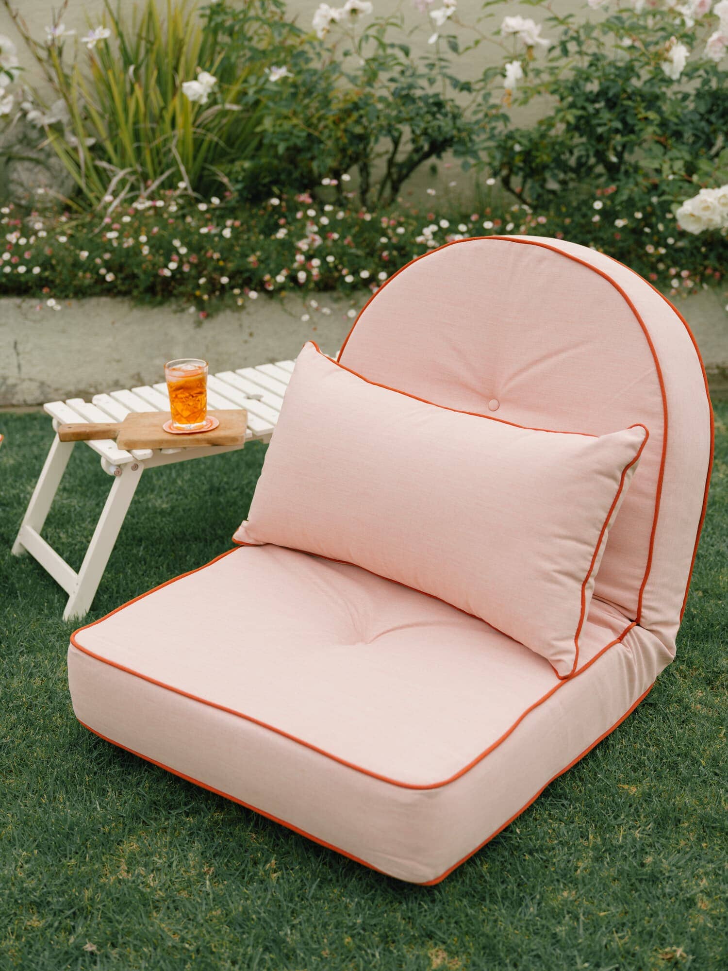 Riviera pink outdoor pillows in a garden setting