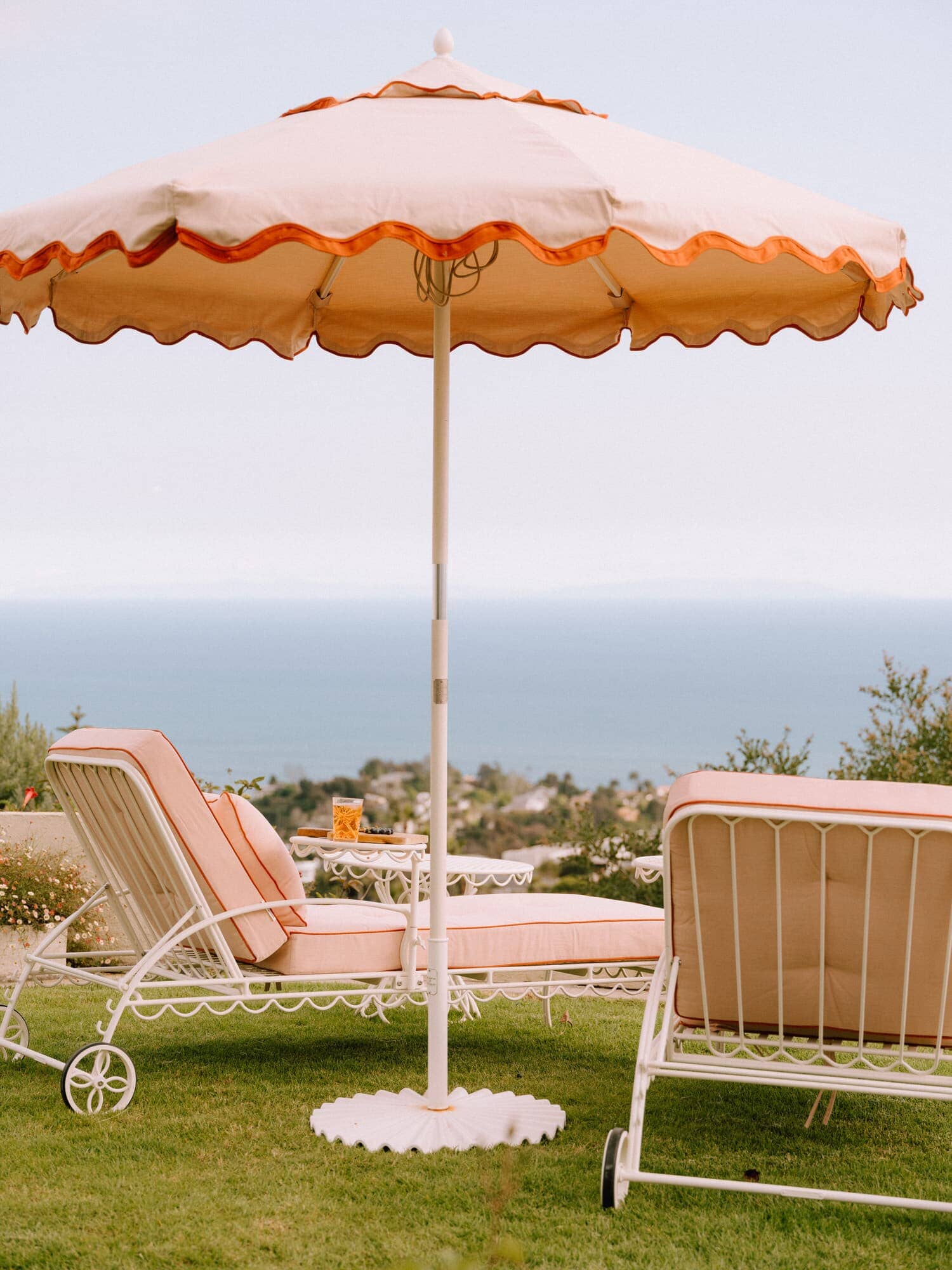 Riviera pink sun loungers and umbrella on the grass