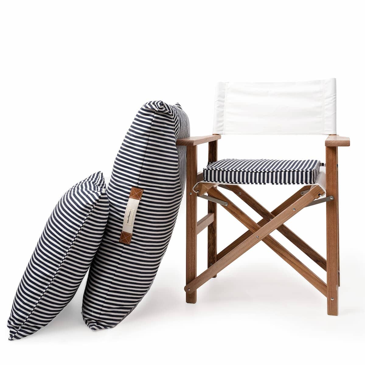 Studio image of navy stripe euro pillow leaning up against a directors chair