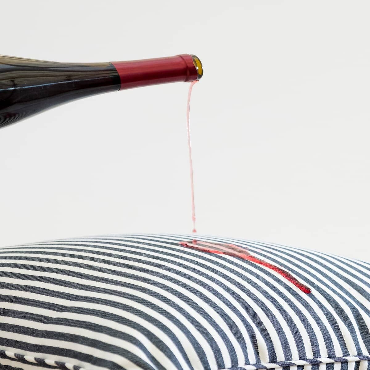 red wine being poured on the floor cushion fabric