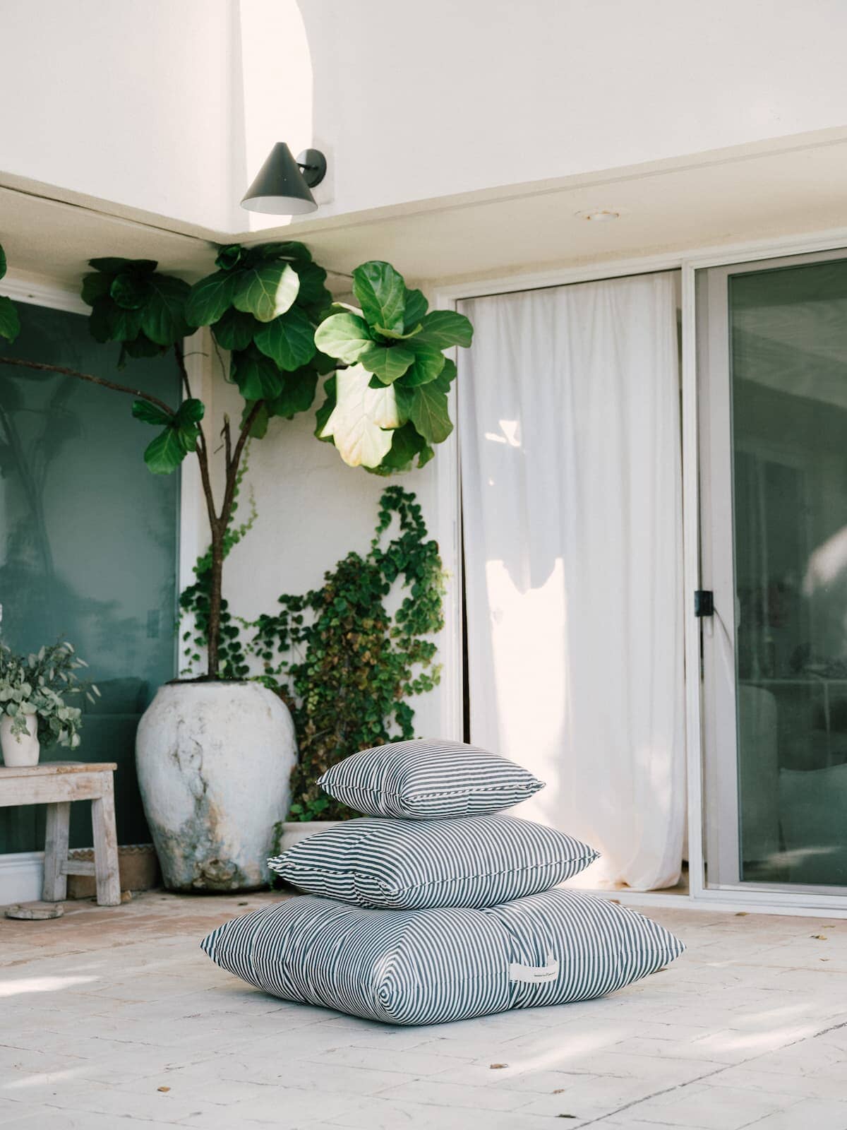 3 throw pillows stacked up on a patio
