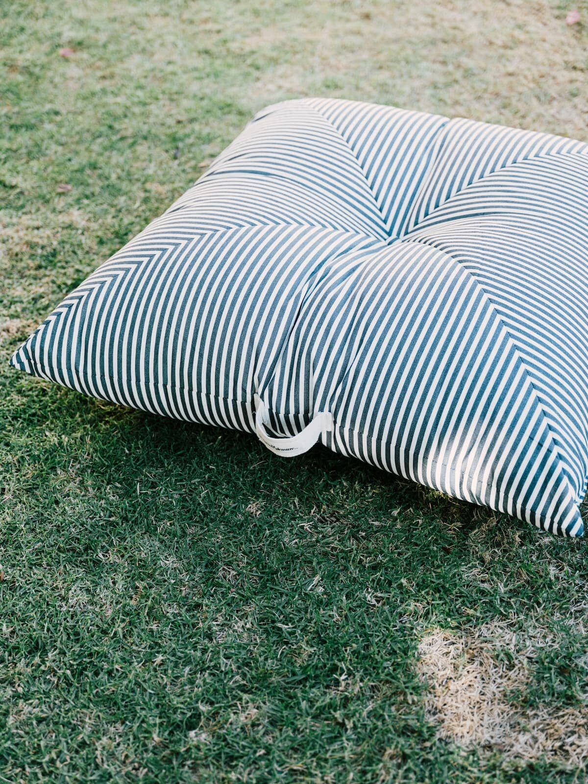 lifestyle image of floor cushion on the grass