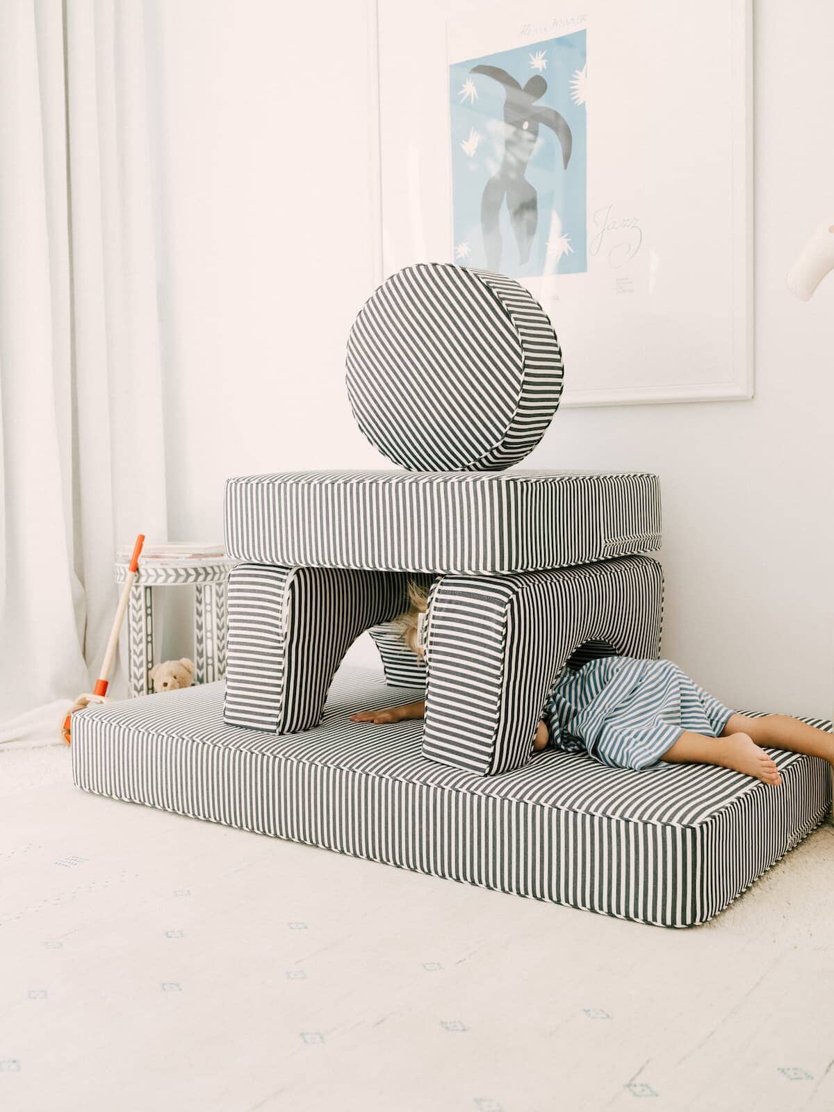 child climbing through pillow stack in bedroom