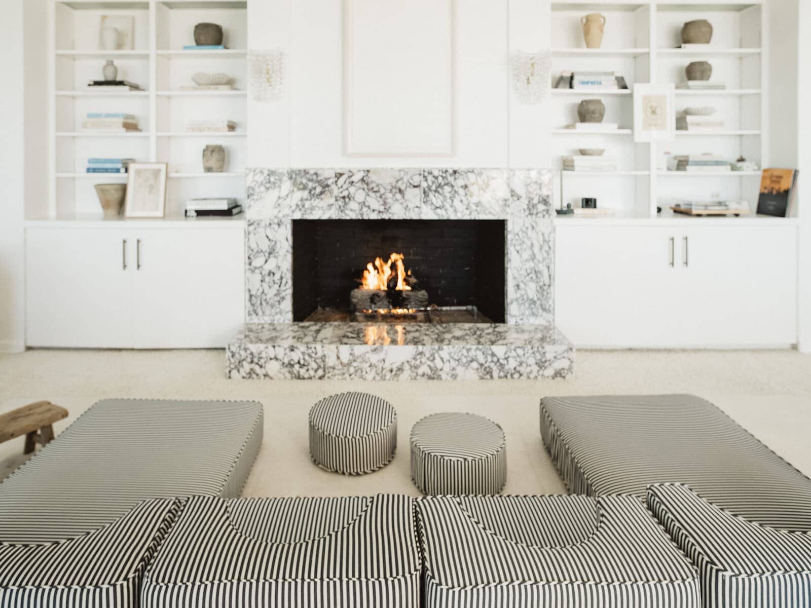pillow stack arranged around fireplace in living room